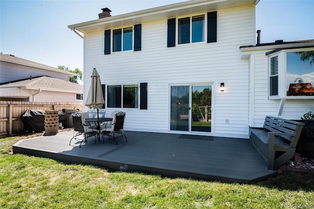 back of house with a wooden deck and a yard