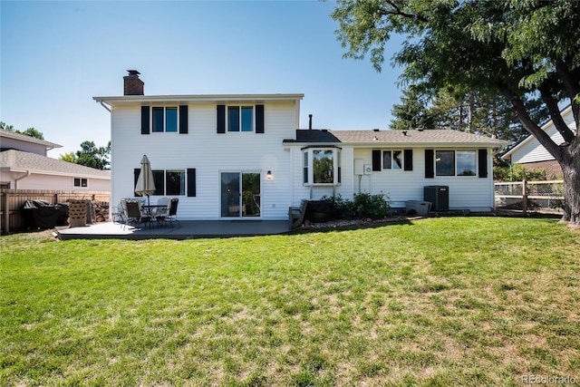 rear view of house with central AC unit, a patio, and a lawn