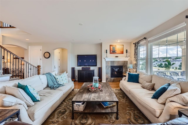 living room featuring wood-type flooring and a tile fireplace