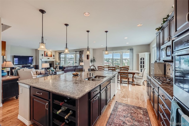 kitchen featuring plenty of natural light, a kitchen island with sink, appliances with stainless steel finishes, and light hardwood / wood-style floors