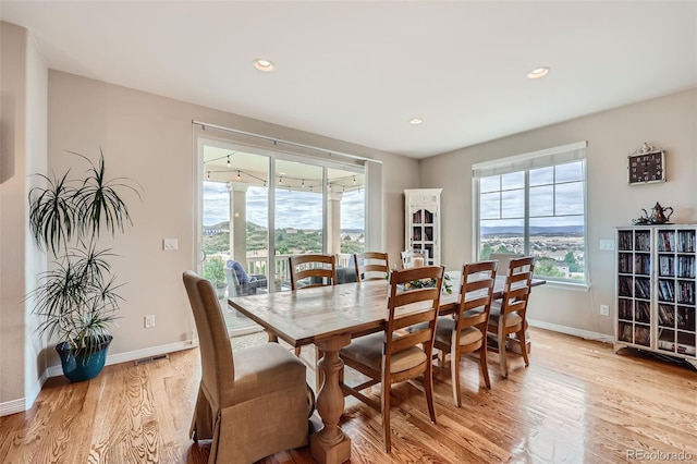 dining space featuring light wood-style flooring, recessed lighting, visible vents, and baseboards