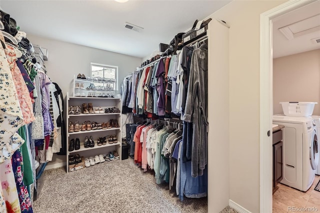 spacious closet featuring washing machine and dryer and light carpet