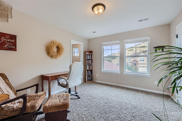 carpeted office space featuring visible vents and baseboards