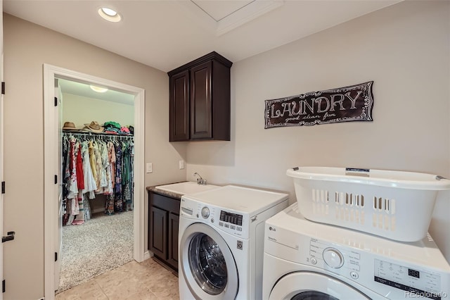 washroom with sink, washing machine and clothes dryer, cabinets, and light tile patterned flooring