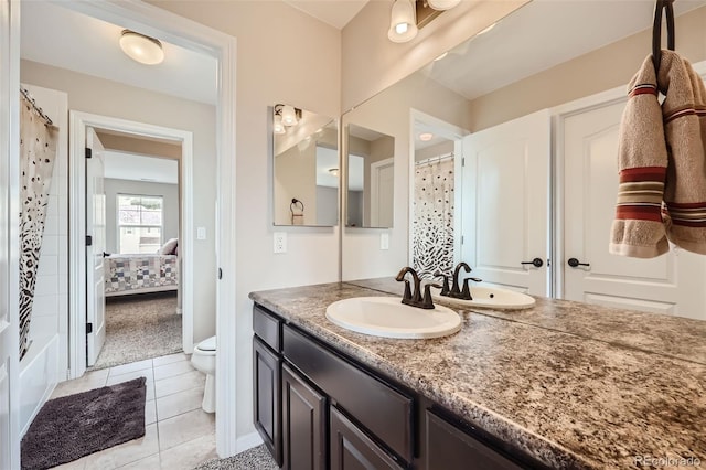 bathroom with toilet, tile patterned flooring, and vanity