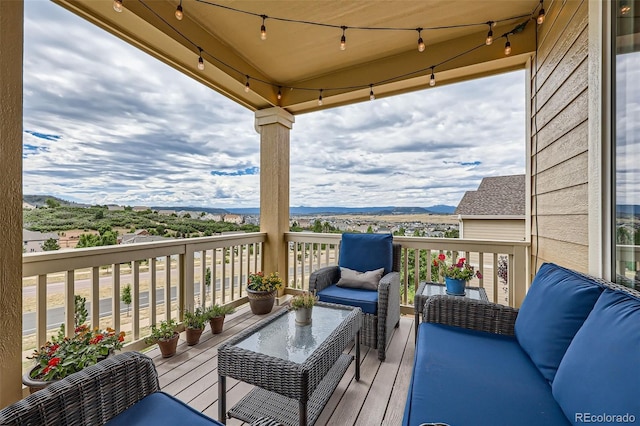 wooden terrace featuring a mountain view and an outdoor living space