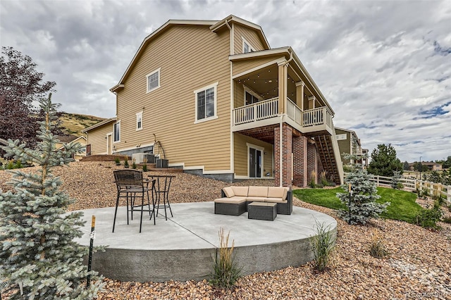 rear view of property featuring a patio, stairs, fence, central air condition unit, and outdoor lounge area