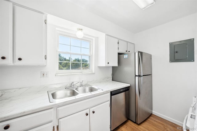 kitchen with sink, stainless steel appliances, light hardwood / wood-style flooring, electric panel, and white cabinets