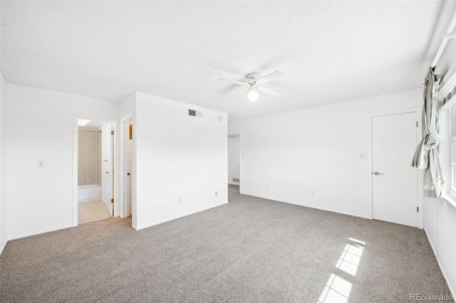 carpeted spare room with a textured ceiling and ceiling fan