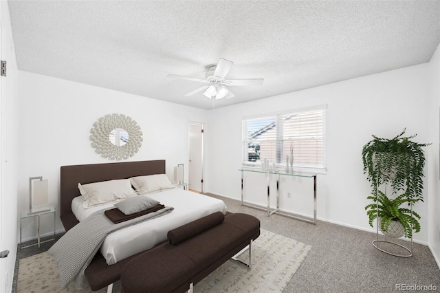 carpeted bedroom with ceiling fan and a textured ceiling