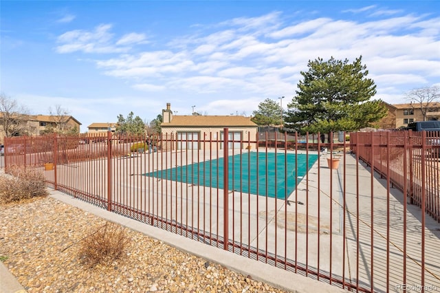 community pool with a patio and fence