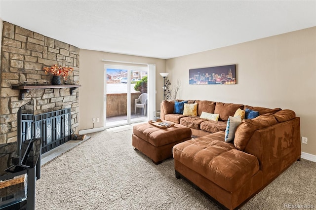 carpeted living room with baseboards and a stone fireplace