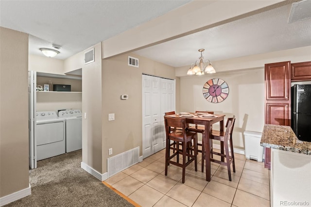 dining room with a chandelier, independent washer and dryer, and visible vents