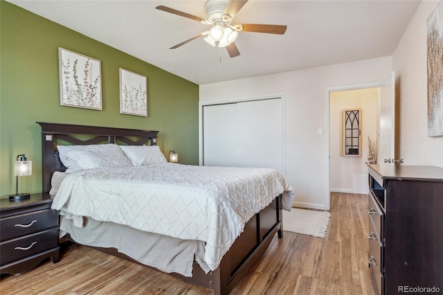 bedroom featuring ceiling fan, a closet, wood finished floors, and baseboards