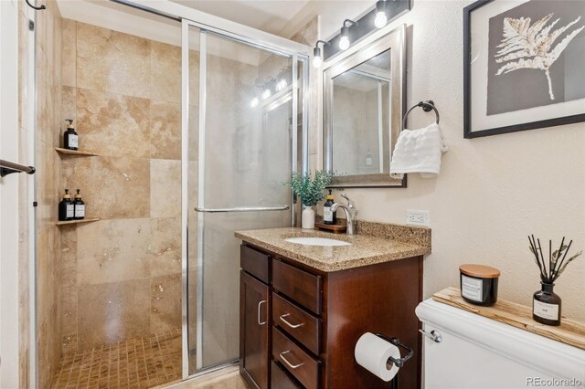 full bath with toilet, a stall shower, and vanity