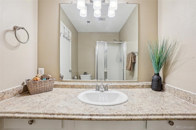 bathroom with toilet, an enclosed shower, and vanity