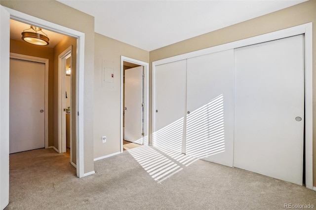 unfurnished bedroom featuring light colored carpet and a closet