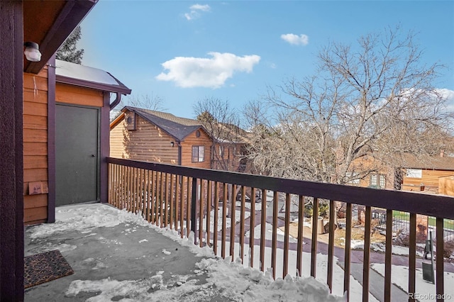 view of snow covered back of property