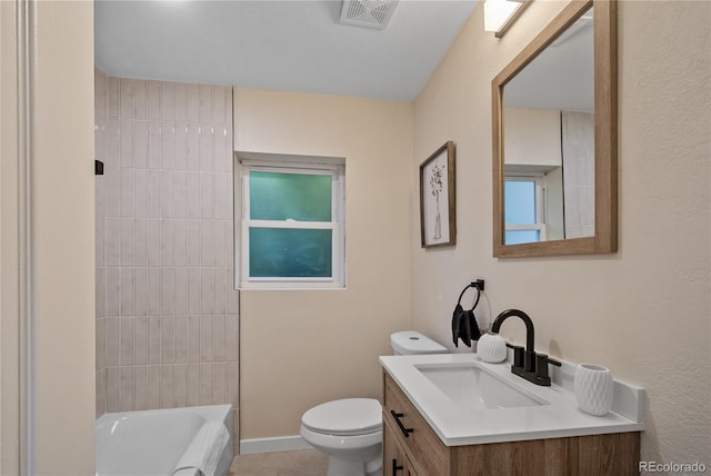 full bathroom with tiled shower / bath, vanity, and toilet