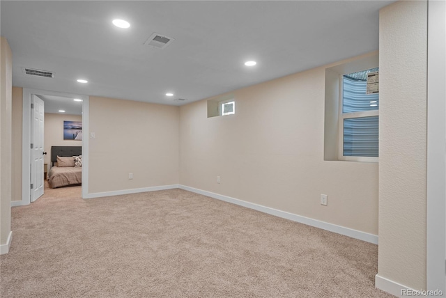 basement featuring light colored carpet