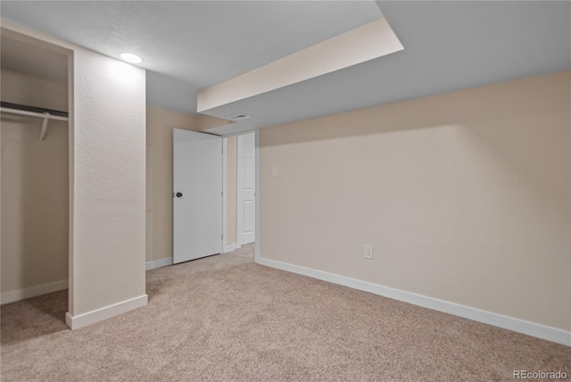 unfurnished bedroom with a closet and light colored carpet