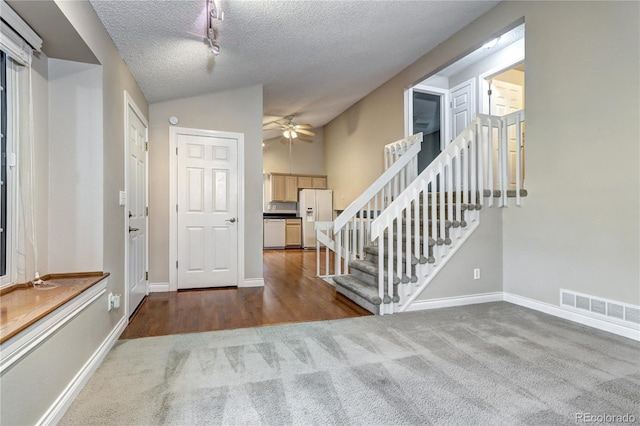 entryway featuring ceiling fan, wood-type flooring, a textured ceiling, and lofted ceiling