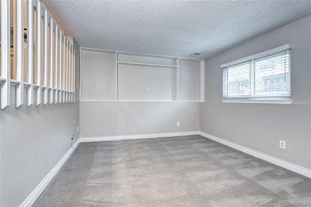 empty room with a textured ceiling and light carpet