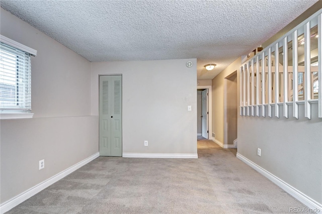 carpeted empty room with a textured ceiling