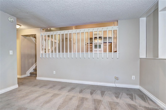 carpeted spare room featuring a textured ceiling