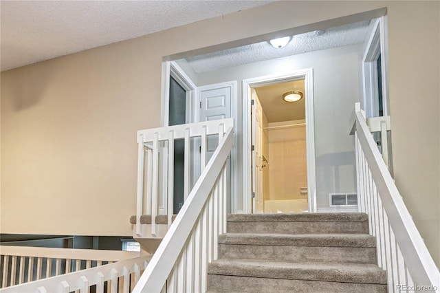 stairs with a textured ceiling