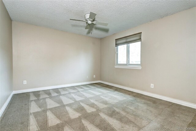 carpeted spare room featuring a textured ceiling and ceiling fan