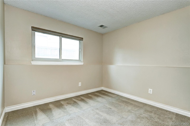 carpeted empty room featuring lofted ceiling and a textured ceiling