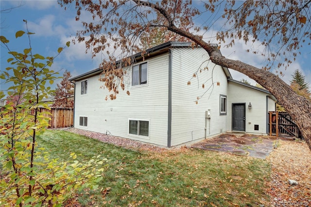 rear view of property featuring a patio and a lawn