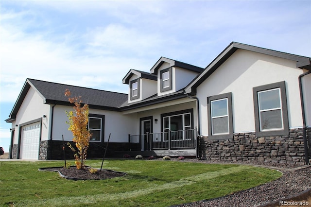 view of front of house featuring an attached garage, stone siding, stucco siding, and a front yard