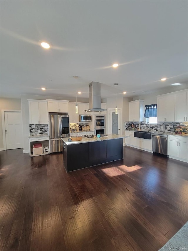 kitchen featuring stainless steel appliances, a kitchen island, white cabinets, hanging light fixtures, and island exhaust hood