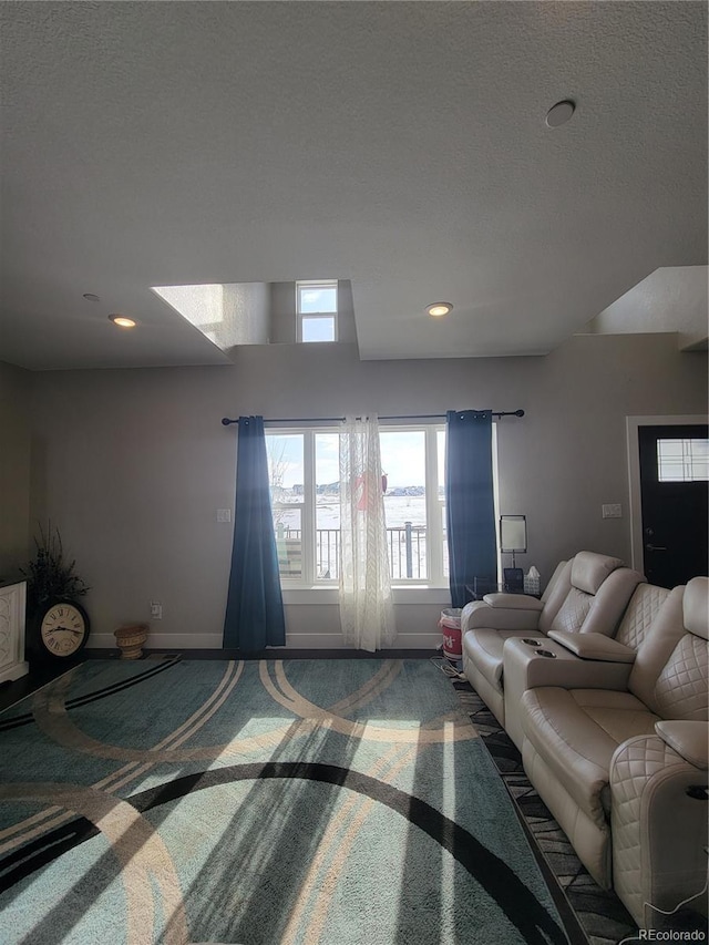 carpeted living area with recessed lighting, a textured ceiling, and baseboards