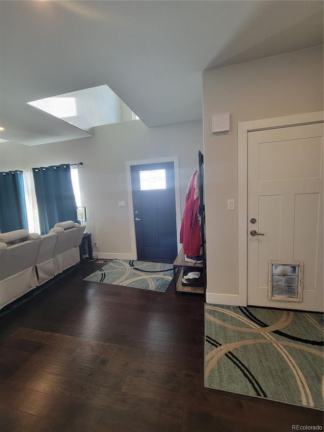 foyer entrance with lofted ceiling, dark wood-type flooring, and baseboards