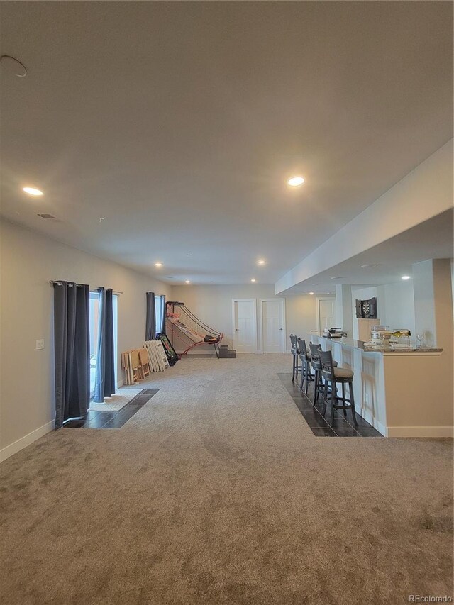 unfurnished living room with dark colored carpet, baseboards, and recessed lighting