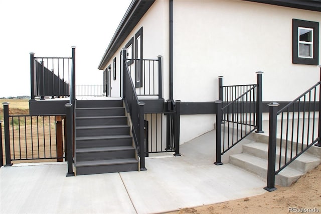 exterior space featuring stairway and stucco siding