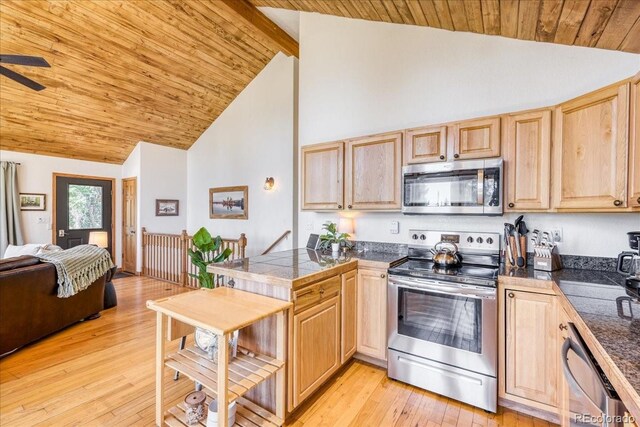 1387 Bobcat Ln, Fairplay, CO 80440 - kitchen featuring appliances with stainless steel finishes, light brown cabinets, a peninsula, a wooden ceiling with exposed beams, and high vaulted ceiling
