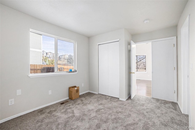 unfurnished bedroom with light carpet and a closet