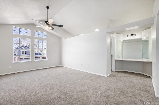 empty room featuring carpet, vaulted ceiling, and ceiling fan