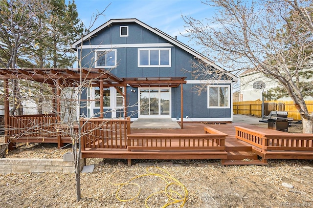 rear view of house with a pergola and a wooden deck