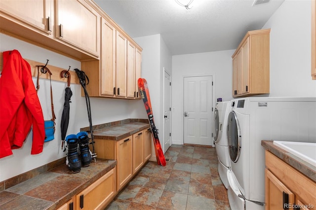 5653 Yank St, Arvada, CO 80002 - laundry room featuring separate washer and dryer, cabinet space, and stone finish floors
