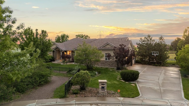 5653 Yank St, Arvada, CO 80002 - view of property hidden behind natural elements with driveway, a tile roof, and a garage