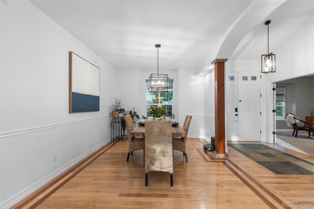 5653 Yank St, Arvada, CO 80002 - dining space with ornate columns, light wood-type flooring, a chandelier, and baseboards