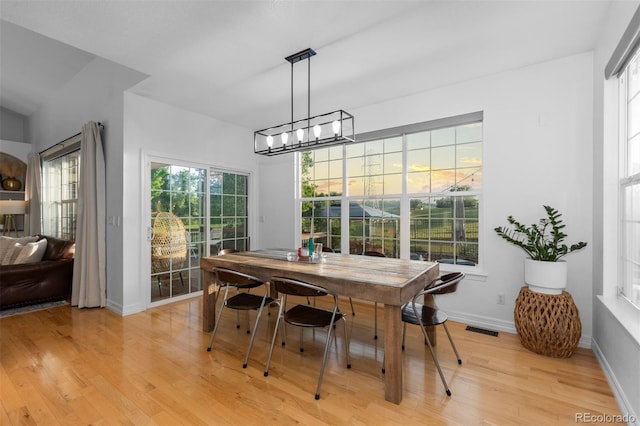 5653 Yank St, Arvada, CO 80002 - dining area with light wood-style flooring, baseboards, and a chandelier