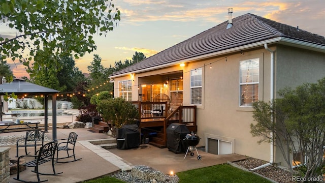 5653 Yank St, Arvada, CO 80002 - rear view of property featuring stucco siding, a patio area, a gazebo, a tiled roof, and a wooden deck