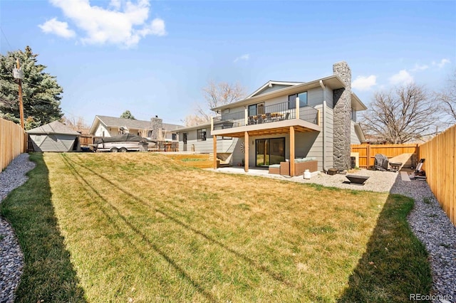 6844 W 69th Pl, Arvada, CO 80003 - rear view of house featuring a fenced backyard, a patio, a balcony, a chimney, and a storage shed