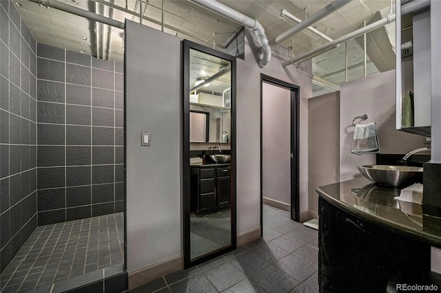 bathroom with vanity and tiled shower